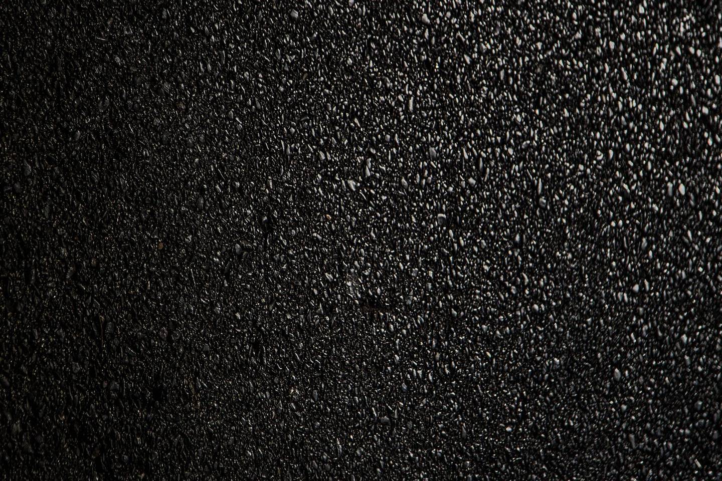 Deep black freshly sealcoated asphalt surface